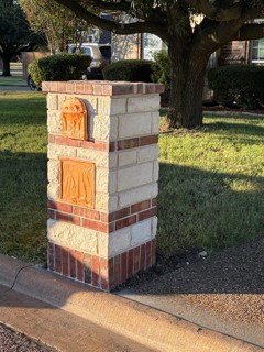 Stone and brick mailbox column with a cap, built by Barefoot